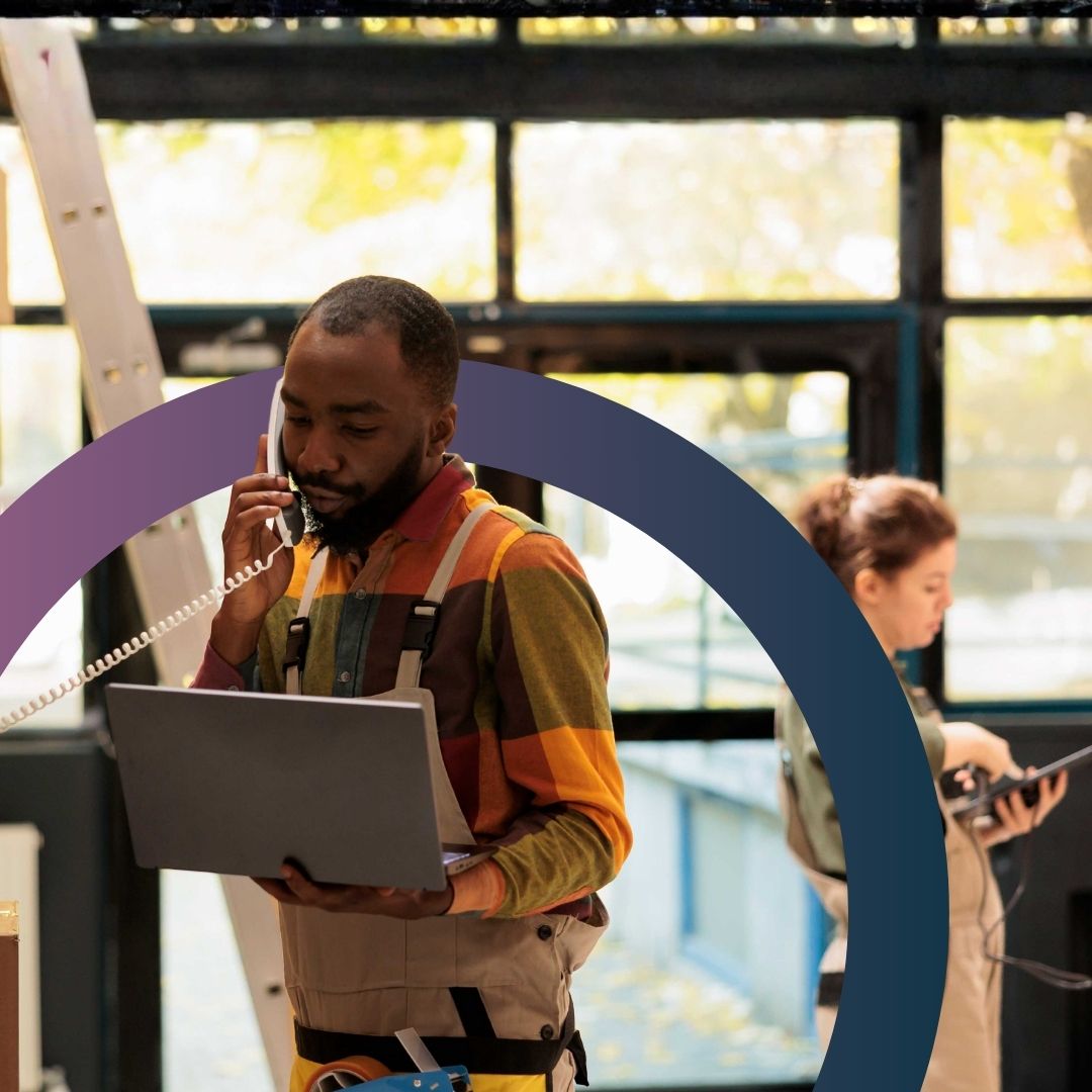 Business owner using smartphone with notebook and laptop in authentic workspace